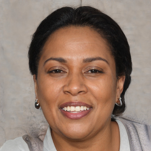 Joyful latino adult female with medium  brown hair and brown eyes