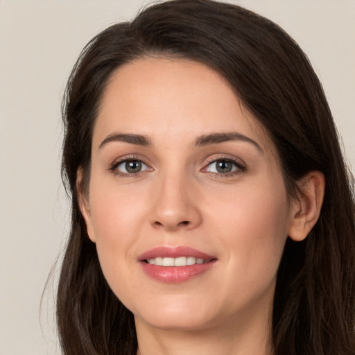 Joyful white young-adult female with long  brown hair and brown eyes