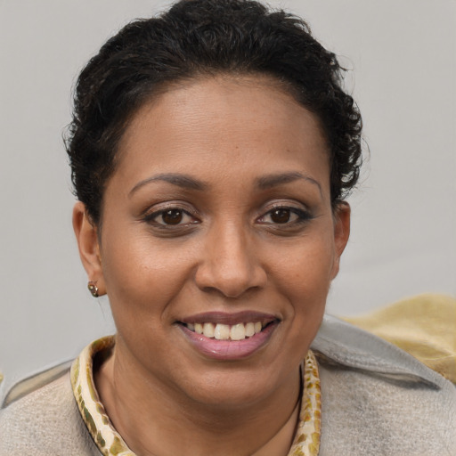 Joyful black young-adult female with short  brown hair and brown eyes