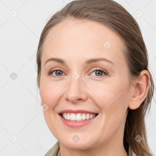 Joyful white young-adult female with long  brown hair and grey eyes