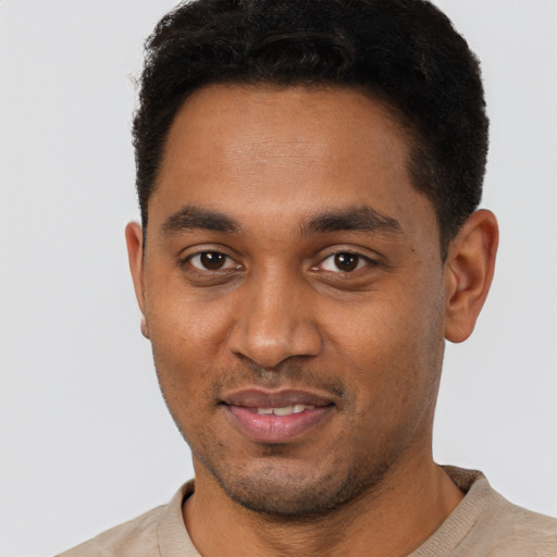 Joyful black young-adult male with short  black hair and brown eyes