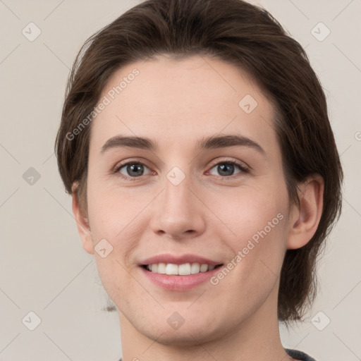 Joyful white young-adult female with medium  brown hair and grey eyes