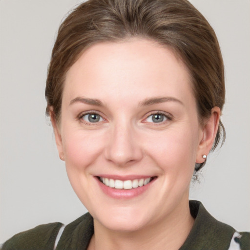 Joyful white young-adult female with medium  brown hair and grey eyes