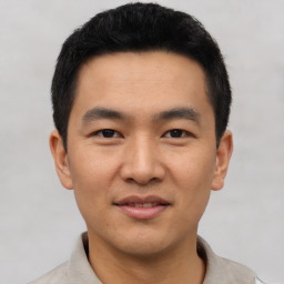 Joyful asian young-adult male with short  black hair and brown eyes