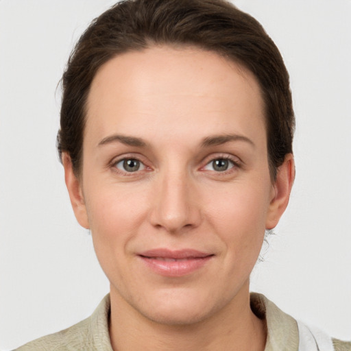 Joyful white young-adult female with short  brown hair and grey eyes