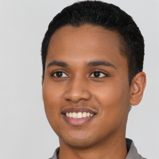Joyful black young-adult male with short  black hair and brown eyes