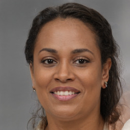 Joyful black adult female with medium  brown hair and brown eyes