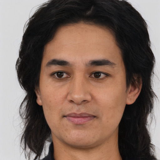 Joyful white young-adult male with long  black hair and brown eyes