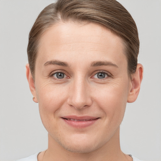 Joyful white young-adult female with short  brown hair and grey eyes