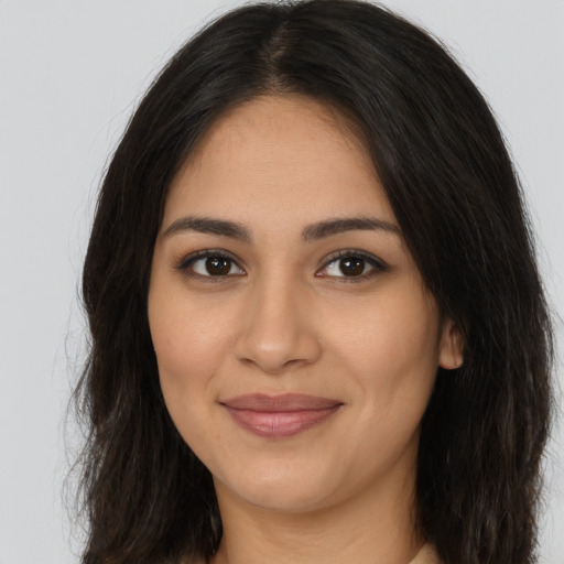 Joyful latino young-adult female with long  brown hair and brown eyes