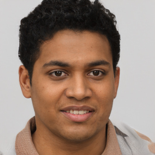 Joyful black young-adult male with short  brown hair and brown eyes