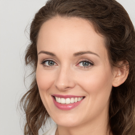 Joyful white young-adult female with medium  brown hair and green eyes