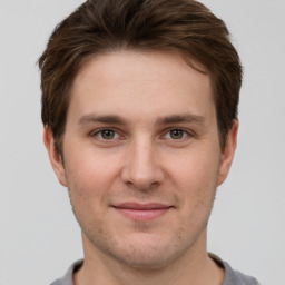 Joyful white young-adult male with short  brown hair and grey eyes