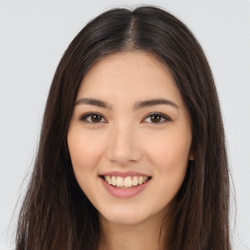 Joyful latino young-adult female with long  brown hair and brown eyes