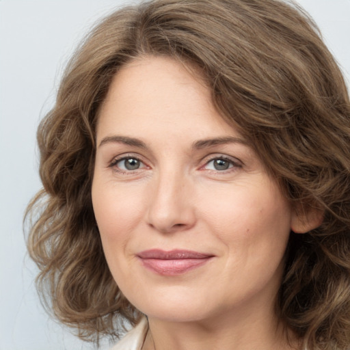 Joyful white young-adult female with medium  brown hair and green eyes