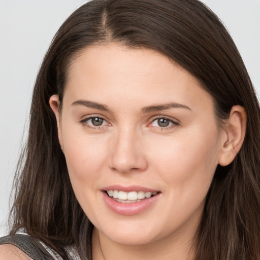 Joyful white young-adult female with long  brown hair and brown eyes