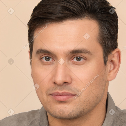 Joyful white young-adult male with short  brown hair and brown eyes