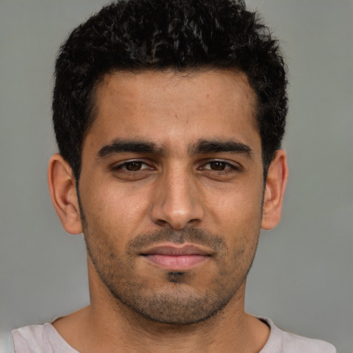 Joyful latino young-adult male with short  brown hair and brown eyes