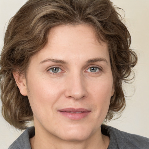 Joyful white adult female with medium  brown hair and grey eyes