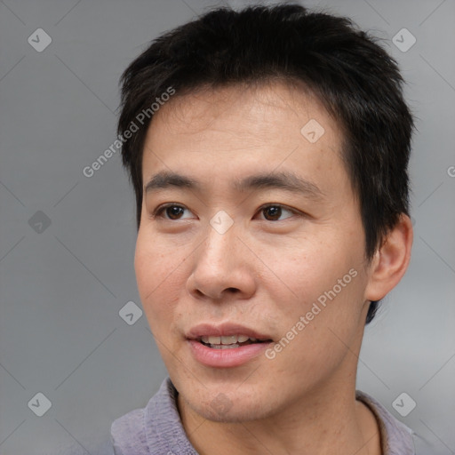 Joyful asian adult male with short  black hair and brown eyes