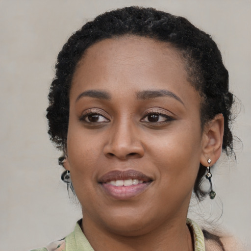 Joyful black young-adult female with long  black hair and brown eyes