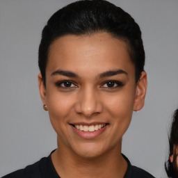 Joyful latino young-adult female with short  black hair and brown eyes