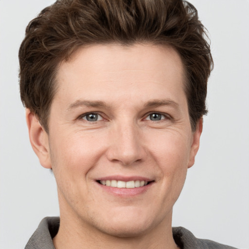 Joyful white adult male with short  brown hair and grey eyes