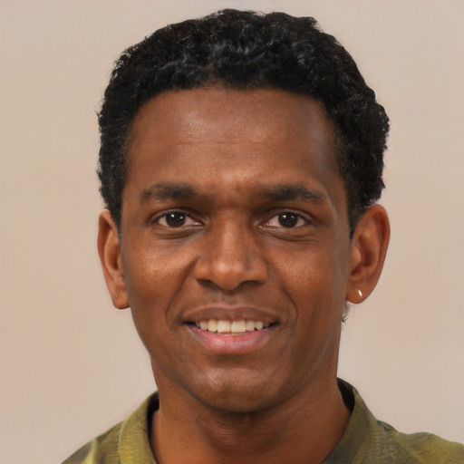 Joyful black adult male with short  black hair and brown eyes