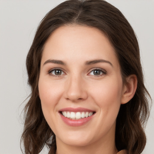 Joyful white young-adult female with long  brown hair and grey eyes