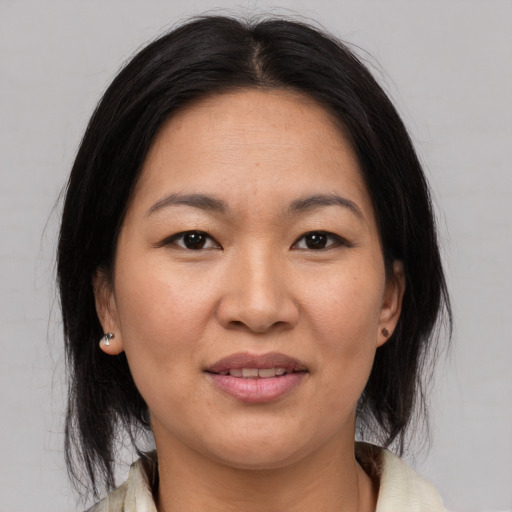 Joyful asian adult female with medium  brown hair and brown eyes