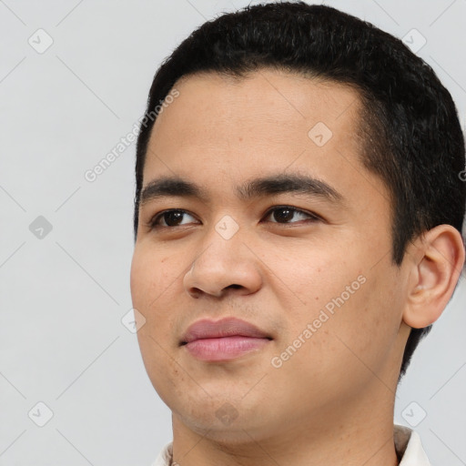 Joyful latino young-adult male with short  black hair and brown eyes