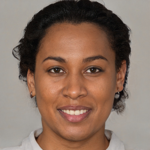 Joyful black young-adult female with short  brown hair and brown eyes
