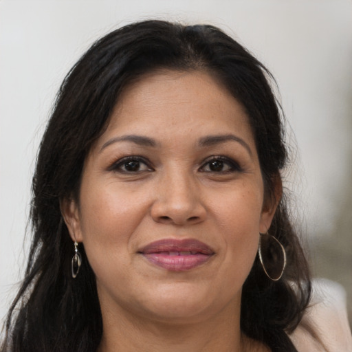 Joyful latino adult female with long  brown hair and brown eyes