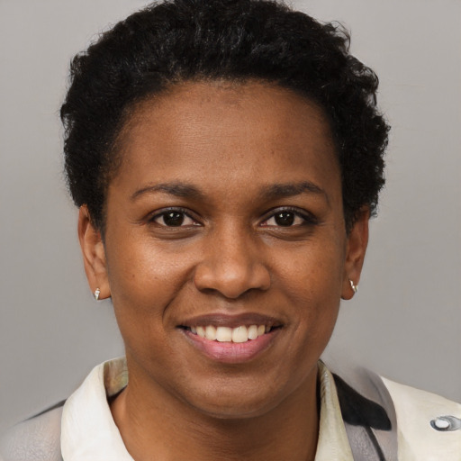 Joyful black young-adult female with short  brown hair and brown eyes