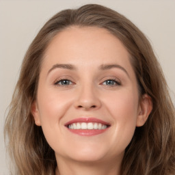 Joyful white young-adult female with long  brown hair and grey eyes