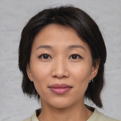 Joyful asian adult female with medium  brown hair and brown eyes