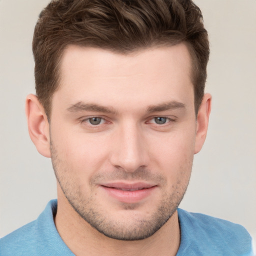 Joyful white young-adult male with short  brown hair and grey eyes