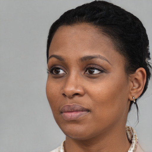 Joyful black young-adult female with medium  black hair and brown eyes