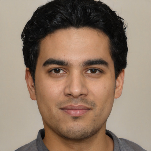 Joyful latino young-adult male with short  black hair and brown eyes