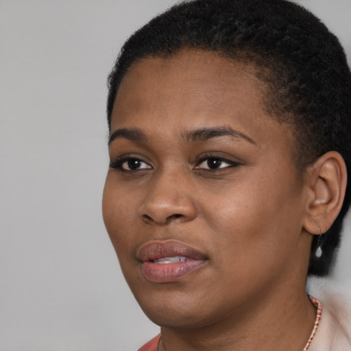 Joyful black young-adult female with short  brown hair and brown eyes