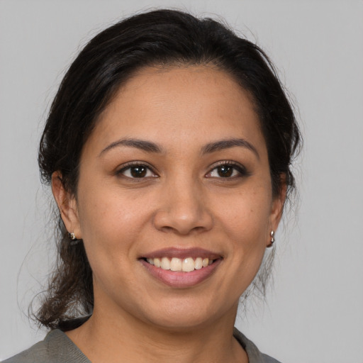 Joyful latino young-adult female with medium  brown hair and brown eyes