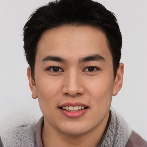 Joyful asian young-adult male with short  brown hair and brown eyes