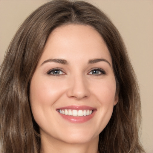 Joyful white young-adult female with long  brown hair and brown eyes