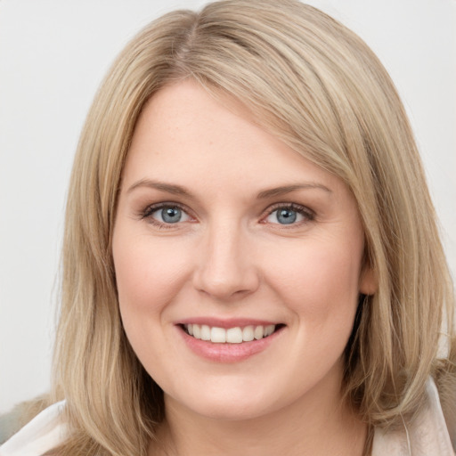 Joyful white young-adult female with long  brown hair and blue eyes