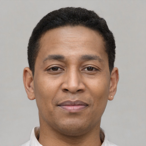 Joyful latino young-adult male with short  brown hair and brown eyes