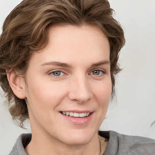 Joyful white young-adult female with medium  brown hair and blue eyes