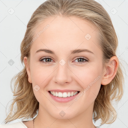 Joyful white young-adult female with medium  brown hair and blue eyes