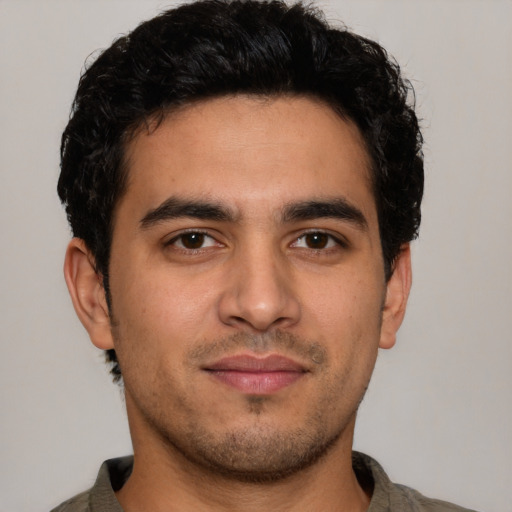 Joyful latino young-adult male with short  brown hair and brown eyes
