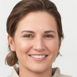 Joyful white young-adult female with medium  brown hair and grey eyes