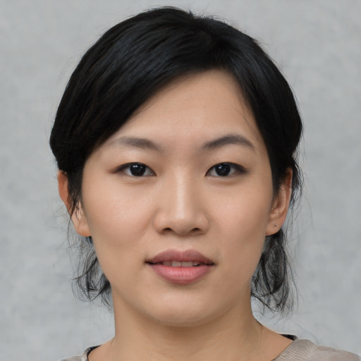 Joyful asian young-adult female with medium  black hair and brown eyes